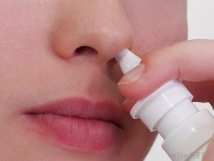 closeup-of-woman-applying-nose-spray-to-nose