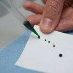 Beads of liquid from a pippette slide off a superhydrophobic surface.